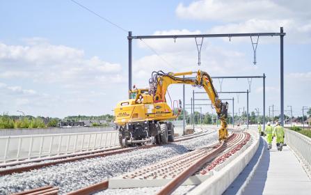 kraan die rails legt.